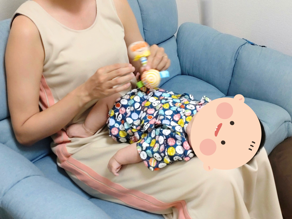 ママの膝の上で過ごしている生後3ヶ月の赤ちゃん