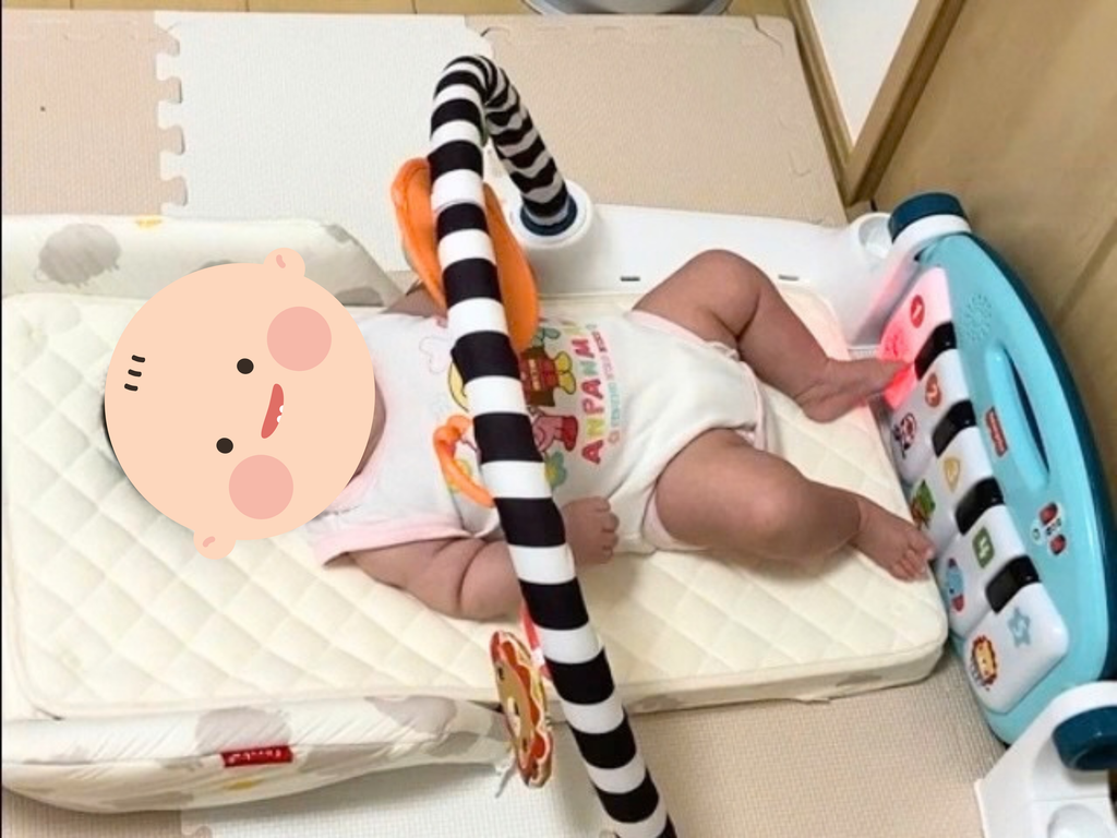 メリーの下で遊んでいる生後3ヶ月の赤ちゃん