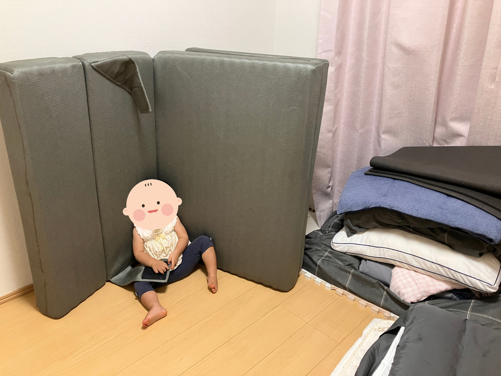 マットレスにもたれて遊ぶ１歳の娘
