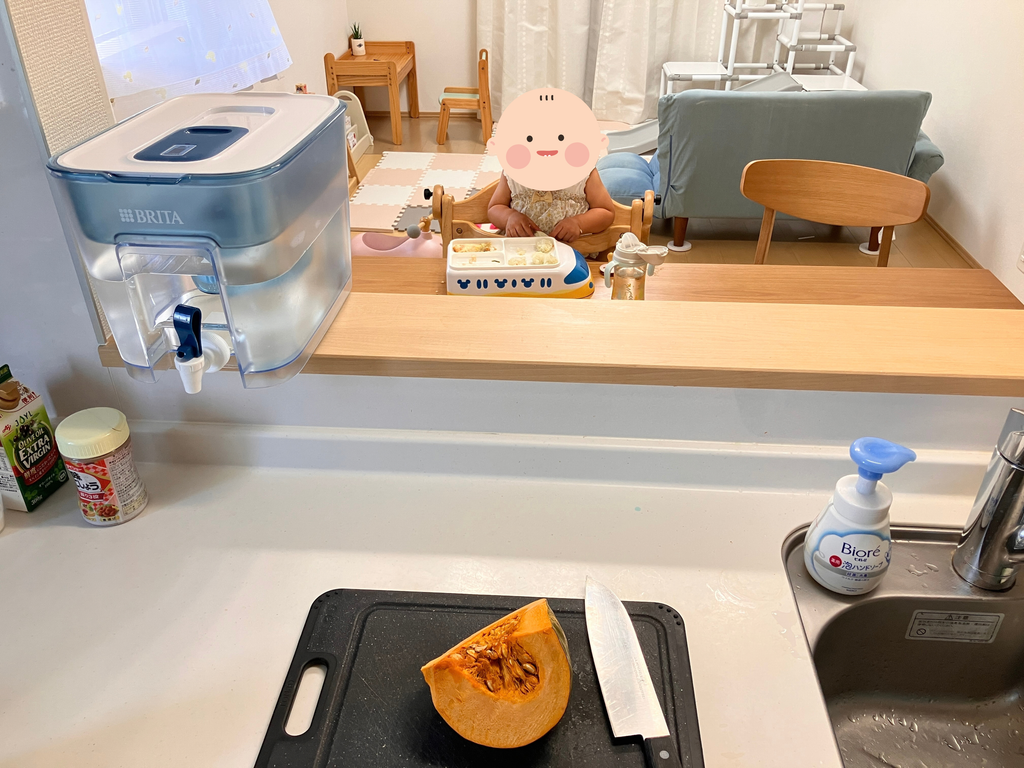 昼食中の１歳の娘を見守りながら、キッチンで料理をする様子